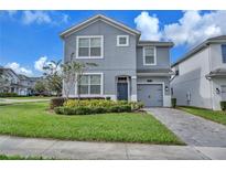 Two-story house with gray siding and a two-car garage at 1592 Flange Dr, Davenport, FL 33896