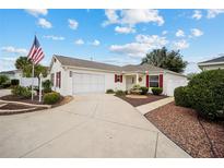 Single-story home with a two-car garage and landscaped yard at 8457 Se 177Th Penman Pl, The Villages, FL 32162