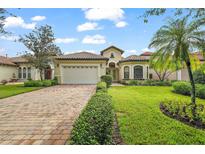 Single-story home with tile roof, paver driveway, and landscaped lawn at 9323 San Jose Blvd, Howey In The Hills, FL 34737