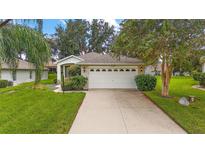 Brick ranch home with a two-car garage and landscaped yard at 5206 Fantasy Way, Leesburg, FL 34748