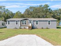 Single-story home with gray siding and a well-manicured lawn at 205 Grove Ridge Dr, Winter Haven, FL 33880