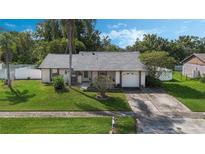 One-story house with a gray roof, white walls, and a well-maintained lawn at 4655 Sturbridge Cir, Orlando, FL 32812