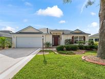 House exterior featuring a two-car garage and well-manicured lawn at 7080 Se 173Rd Arlington Loop, The Villages, FL 32162