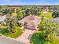 Single-Gathering home with a paved driveway and golf course view at 1828 Madero Dr, The Villages, FL 32159