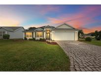 Attractive single-story home with landscaped yard and paver driveway at 1401 Valparaiso St, The Villages, FL 32162