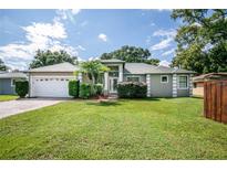 Single-story home with a two-car garage and well-maintained lawn at 27637 Lisa Dr, Tavares, FL 32778