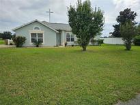 Light blue house with a large green yard at 36641 Tropical Wind Ln, Grand Island, FL 32735