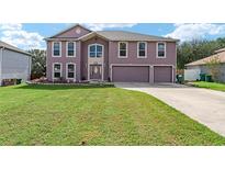 Two-story house with a three-car garage and landscaped yard at 1119 Myrtle Lake View Dr, Fruitland Park, FL 34731