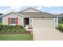 Single-story home with gray siding, red shutters, and a two-car garage at 5120 Tanzanite Dr, Mount Dora, FL 32757