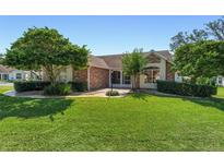 Brick house with a well-maintained lawn and landscaping at 315 Gonzales Pl, The Villages, FL 32159