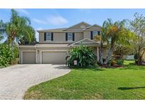 Two-story house with a three-car garage and landscaped yard at 5020 Neptune Cir, Oxford, FL 34484