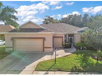 Single-story home with attached garage and landscaped lawn at 3828 Arbordale Ct, Leesburg, FL 34748