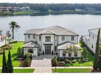 Lakefront home with modern architecture and landscaped yard at 16820 Bolsena Dr, Bella Collina, FL 34756