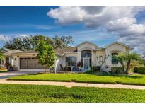 One-story home with attached garage, landscaping, and a spacious front yard at 5839 Woodland Moss Way, Leesburg, FL 34748