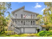 Two-story home with gray siding, white trim, and a large deck at 7373 Circle Dr, Lady Lake, FL 32159