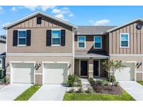 Two-story townhome with attached garages and landscaping at 1496 Mirabella Cir, Davenport, FL 33897