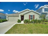 Single-story home with two-car garage, landscaping, and a charming curb appeal at 656 Daring Dr, Davenport, FL 33837