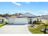 Two-car garage home with landscaped front yard at 4353 Cameo Cir, The Villages, FL 32163