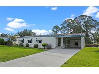 Single-wide manufactured home with carport and landscaped yard at 1020 Hilltop Rd, Tavares, FL 32778