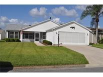 House exterior featuring a two-car garage and well-maintained lawn at 2189 Broxton Pl, The Villages, FL 32162