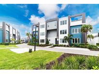 Modern townhouses with landscaped grounds and a curved driveway at 7740 Sandy Ridge Dr # 106, Reunion, FL 34747