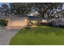 One-story house with a large front yard and attached garage at night at 8194 Se 177Th Winterthur Loop, The Villages, FL 32162