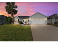 A charming single-story home with a two-car garage and manicured lawn at 1312 Landeros Ln, The Villages, FL 32159