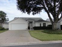 One-story house with two-car garage and landscaped yard at 3425 Dixon Ln, The Villages, FL 32162