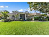 Single-story home with landscaped lawn and teal door at 3509 Indian Trl, Eustis, FL 32726