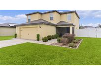 Two-story house with a two-car garage and landscaped yard at 1136 Sea Pines Ct, Tavares, FL 32778