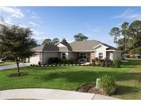 One-story home with stone accents and landscaped yard at 34932 Golden Tree Dr, Leesburg, FL 34788