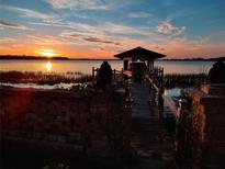 Sunset view of a private boat dock with access to the water at 6118 Dora Dr, Mount Dora, FL 32757