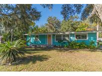 Charming teal home with a well-manicured lawn and mature trees at 2602 Cr 422, Lake Panasoffkee, FL 33538