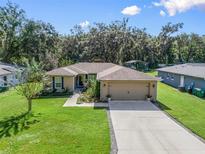 House exterior with a two-car garage and landscaping at 966 Barwick Street, Wildwood, FL 34785