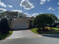 House exterior featuring a brick driveway and landscaping at 21630 King Henry Ave, Leesburg, FL 34748