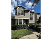 Two-story house with gray siding, large windows, and well-manicured landscaping at 12144 Bruceton Way # 101, Orlando, FL 32828