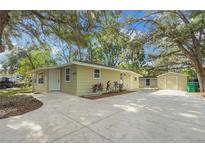 Tan house with a large yard and detached garage at 34929 Cutoff Rd, Fruitland Park, FL 34731