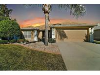 One-story home with landscaped lawn, attached garage, and palm trees at 13437 Se 86Th Cir, Summerfield, FL 34491