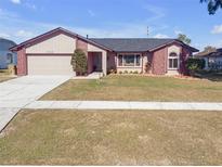 Brick and shingle ranch home with a two-car garage and landscaped yard at 7715 Indian Ridge N Trl, Kissimmee, FL 34747