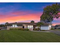 Single-story house with a brick facade, a large lawn, and a two-car garage at 1621 Texas Ct, Tavares, FL 32778