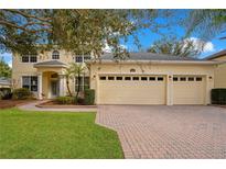 Two-story house with a three-car garage and a landscaped lawn at 4236 Fawn Meadows Cir, Clermont, FL 34711