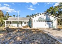 Ranch-style home with a carport and mature landscaping at 17469 Sw 35Th Avenue Rd, Ocala, FL 34473