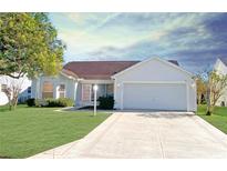 White single story home with attached garage, and well manicured lawn at 2051 Palo Alto Ave, The Villages, FL 32159