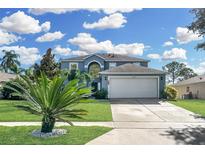 Two-story house with a gray exterior, white garage door, and landscaping at 1087 Welch Hill Cir, Apopka, FL 32712