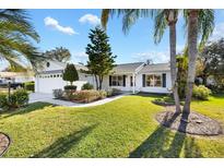 Single-story home with a well-maintained lawn and landscaping at 1201 De La Fuente Ct, The Villages, FL 32162