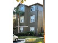 View of the building's exterior with gray siding, white windows, and a palm tree at 420 Summit Ridge Pl # 214, Longwood, FL 32779