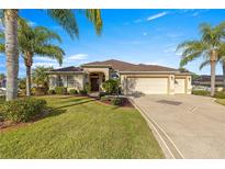 Single-story house with a three-car garage and lush landscaping at 1039 Powderville, The Villages, FL 32162