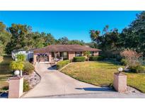 Ranch style home with circular driveway, landscaped lawn, and decorative fountain at 316 Amanda Ln, Leesburg, FL 34748