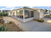 Backyard with a screened porch and a concrete patio at 1702 Abasco Ct, The Villages, FL 32162