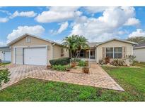 Charming single-story home with a two-car garage, landscaped front yard, and paver walkway at 17648 Se 93Rd Butler Ct, The Villages, FL 32162